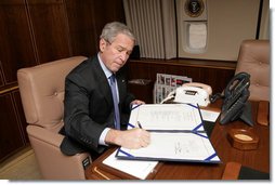 President George W. Bush signs into law H.R. 2764, the Consolidated Appropriations Act 2008, also known at the omnibus, making appropriations for the Department of State, foreign operations, and related programs for the fiscal year ending September 30, 2008, and for other purposes, after boarding Air Force One Wednesday, Dec. 26, 2007. White House photo by Chris Greenberg
