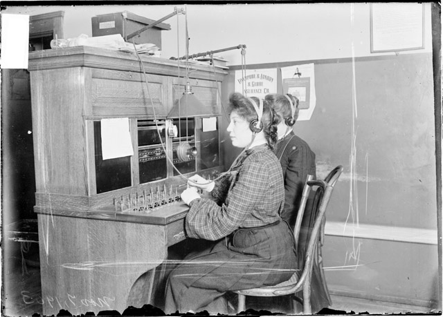 Image of two Chicago Daily News telephone operators sitting at a switchboard in Chicago, Illinois.